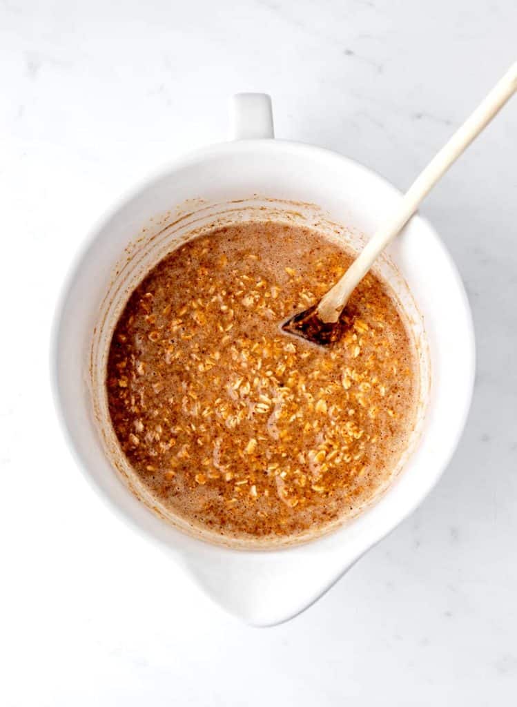 Oats stirred into the wet ingredients to make baked oatmeal.