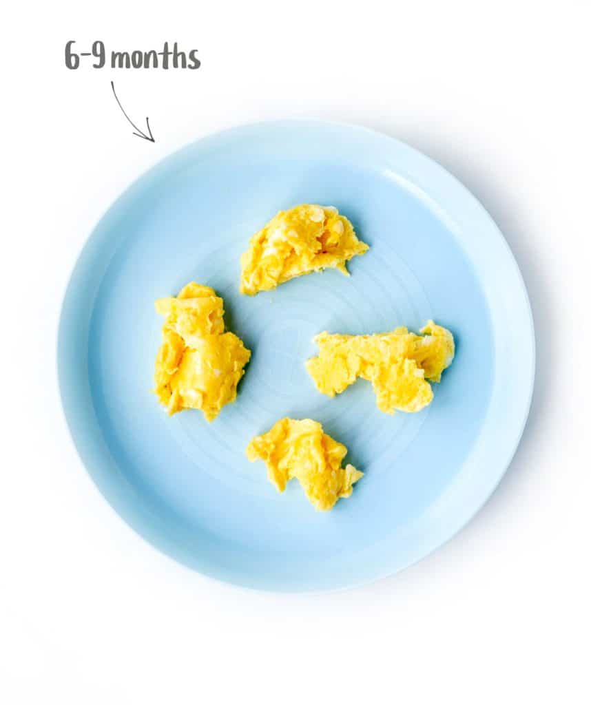 Scrambled eggs for 6 month old baby on a blue plate.