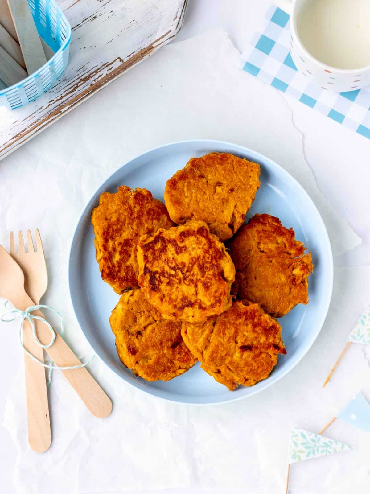 A plate of sweet potato patties next to some forks.