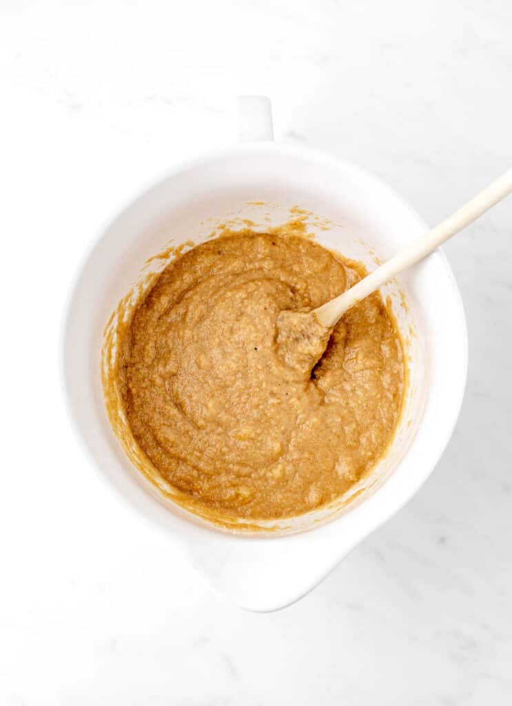 The dry ingredients added to the wet ingredients in a bowl for baby banana bread.