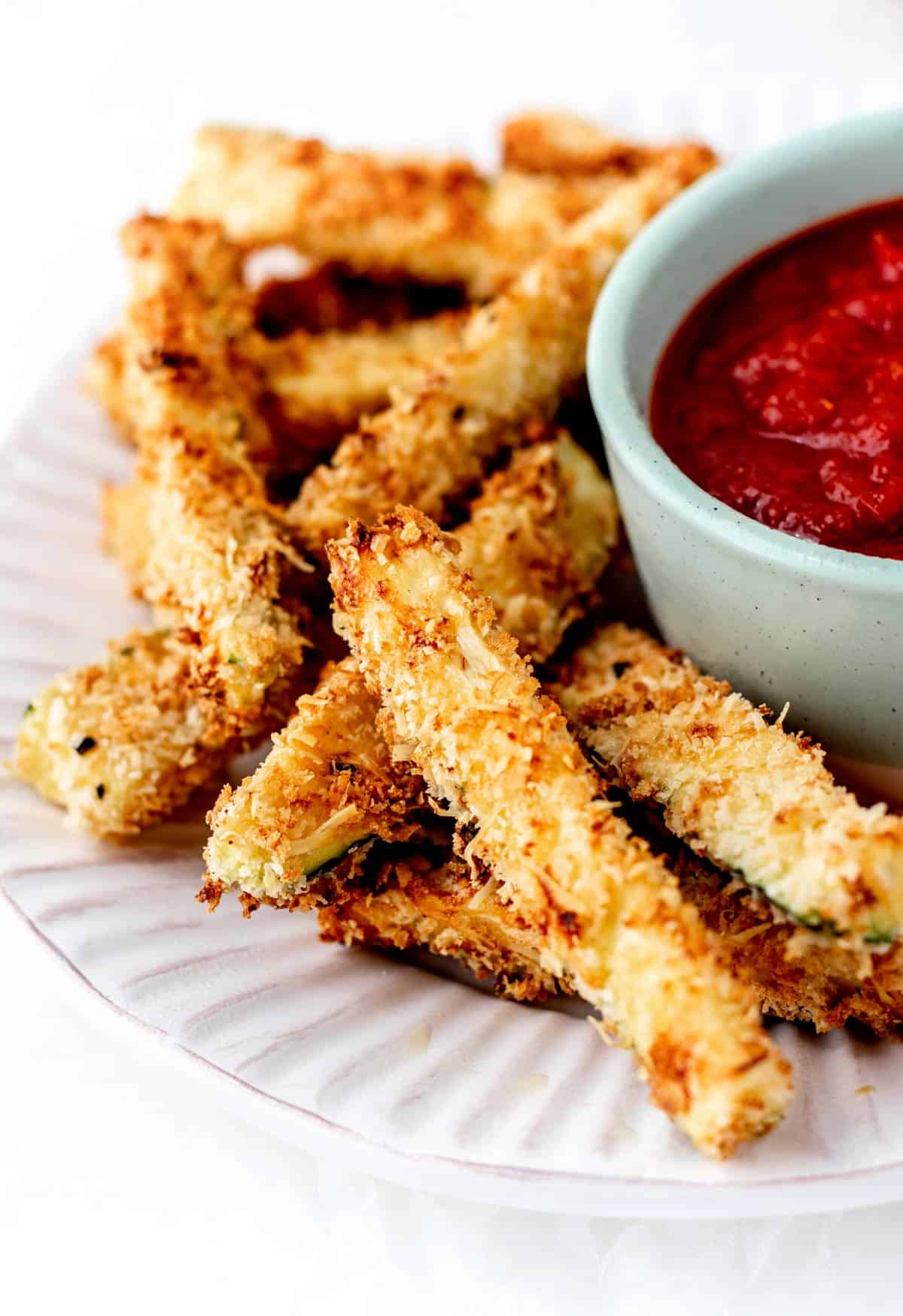 Crispy air fryer zucchini fries on a plate.