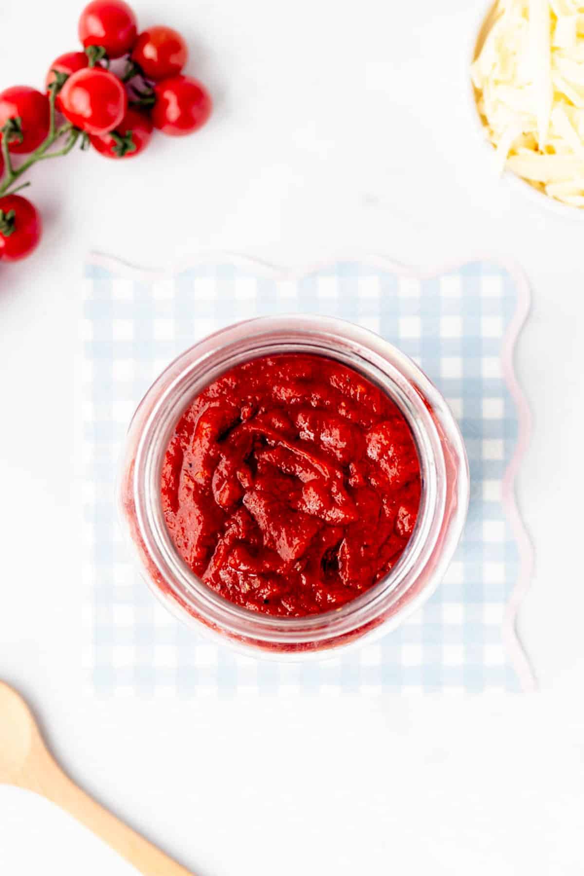 Overhead image of pizza sauce in a jar.