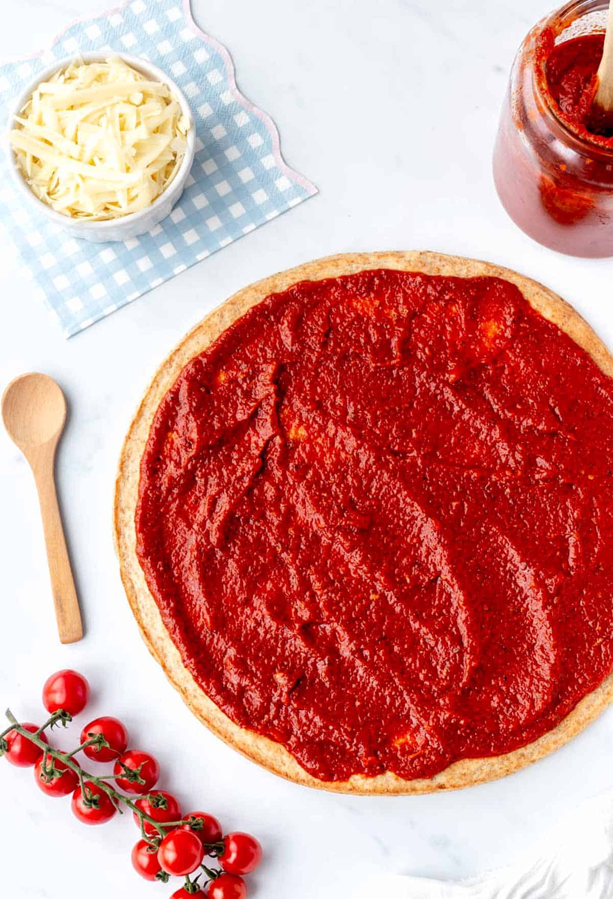 Pizza crust spread with some low sodium pizza sauce.