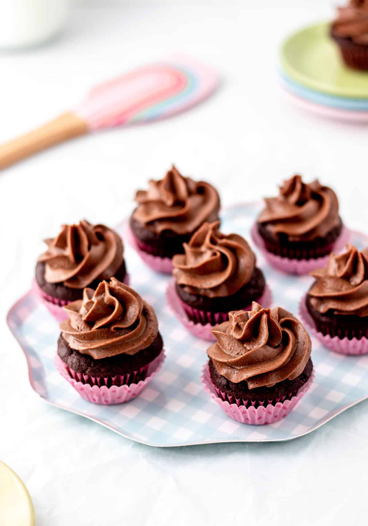 Mini cupcakes with chocolate frosting without powdered sugar piped on.