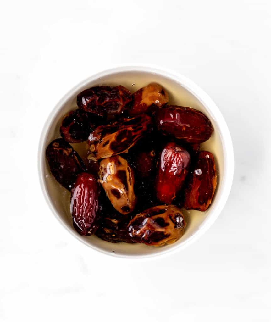 Dates soaking in a bowl of hot water.