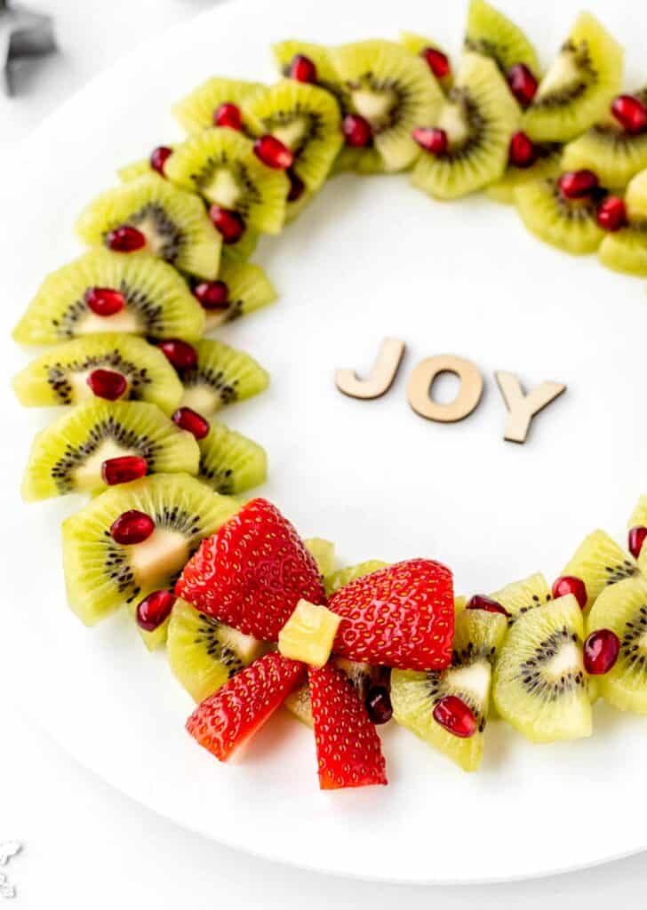 An angled image of holiday fruit platter on a white plate.