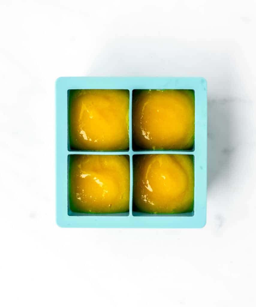 Mango puree in a silicone ice cube tray.