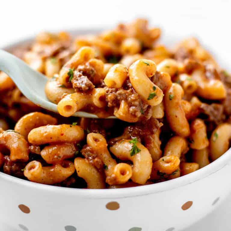 Close up image of a fork digging into a bowl of homemade healthy hamburger helper.