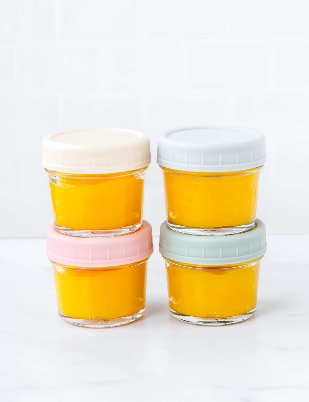 Four jars with baby mango puree.