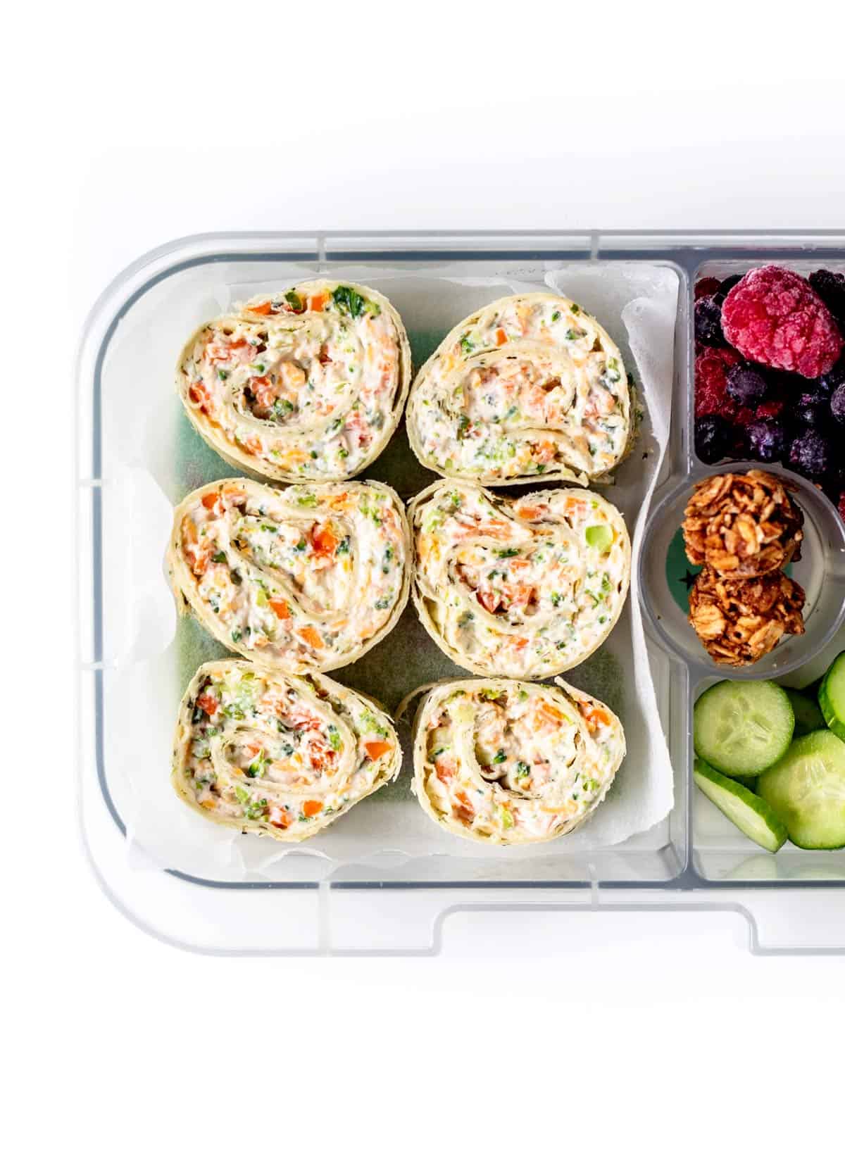 A lunch box with six broccoli and cheese pinwheels.