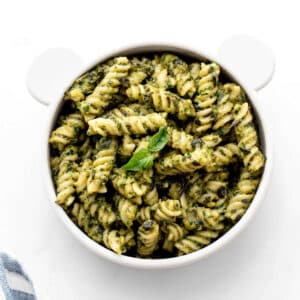 Baby pasta recipe with green sauce in a small teddy bear bowl.