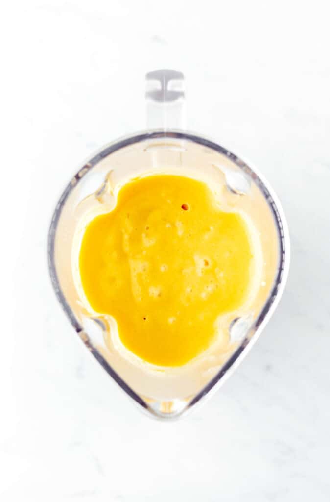 Mango and coconut milk blended up in a blender to make popsicles for toddlers.