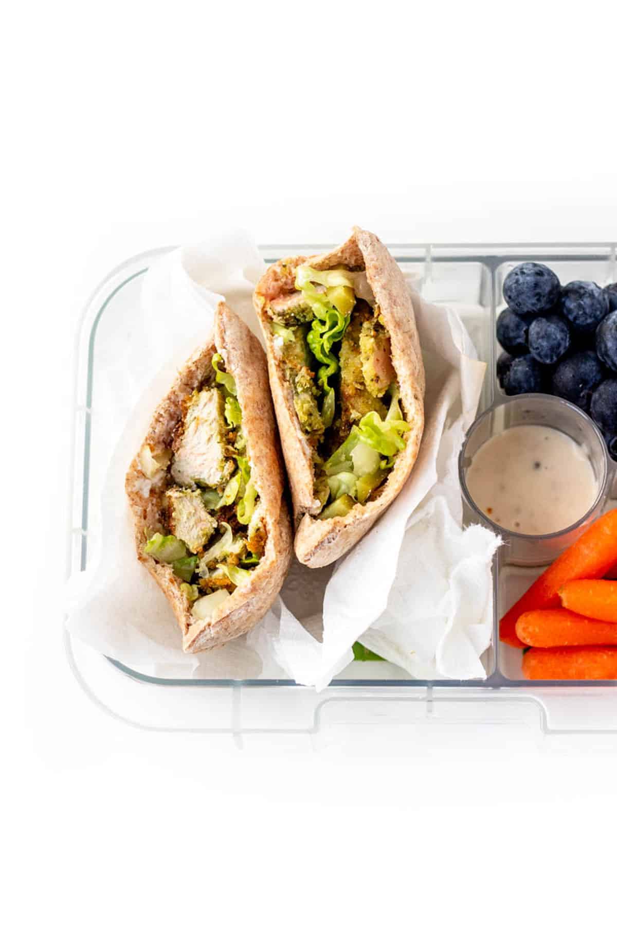 A chicken pita with carrots and blueberries.