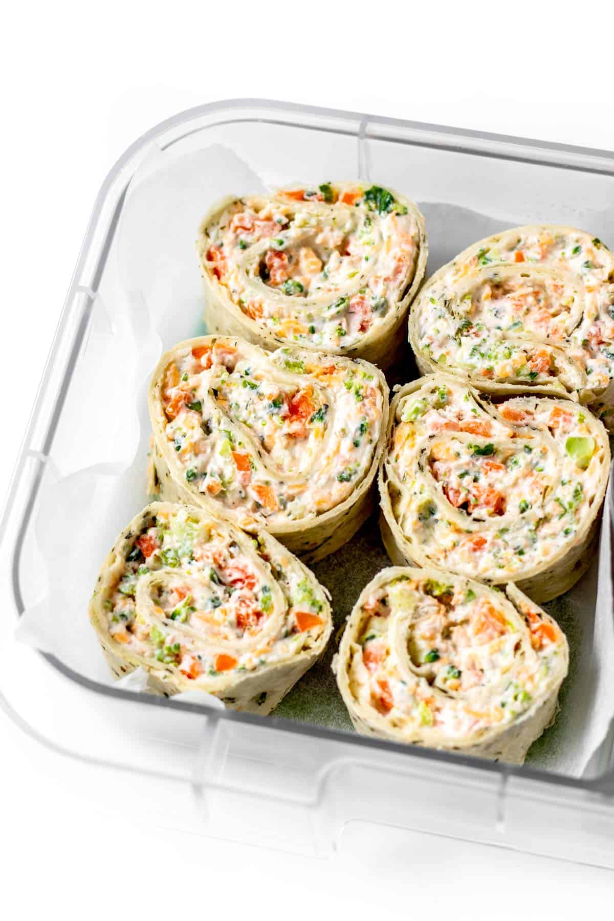 Up close image of six veggie pinwheels in a lunch box.