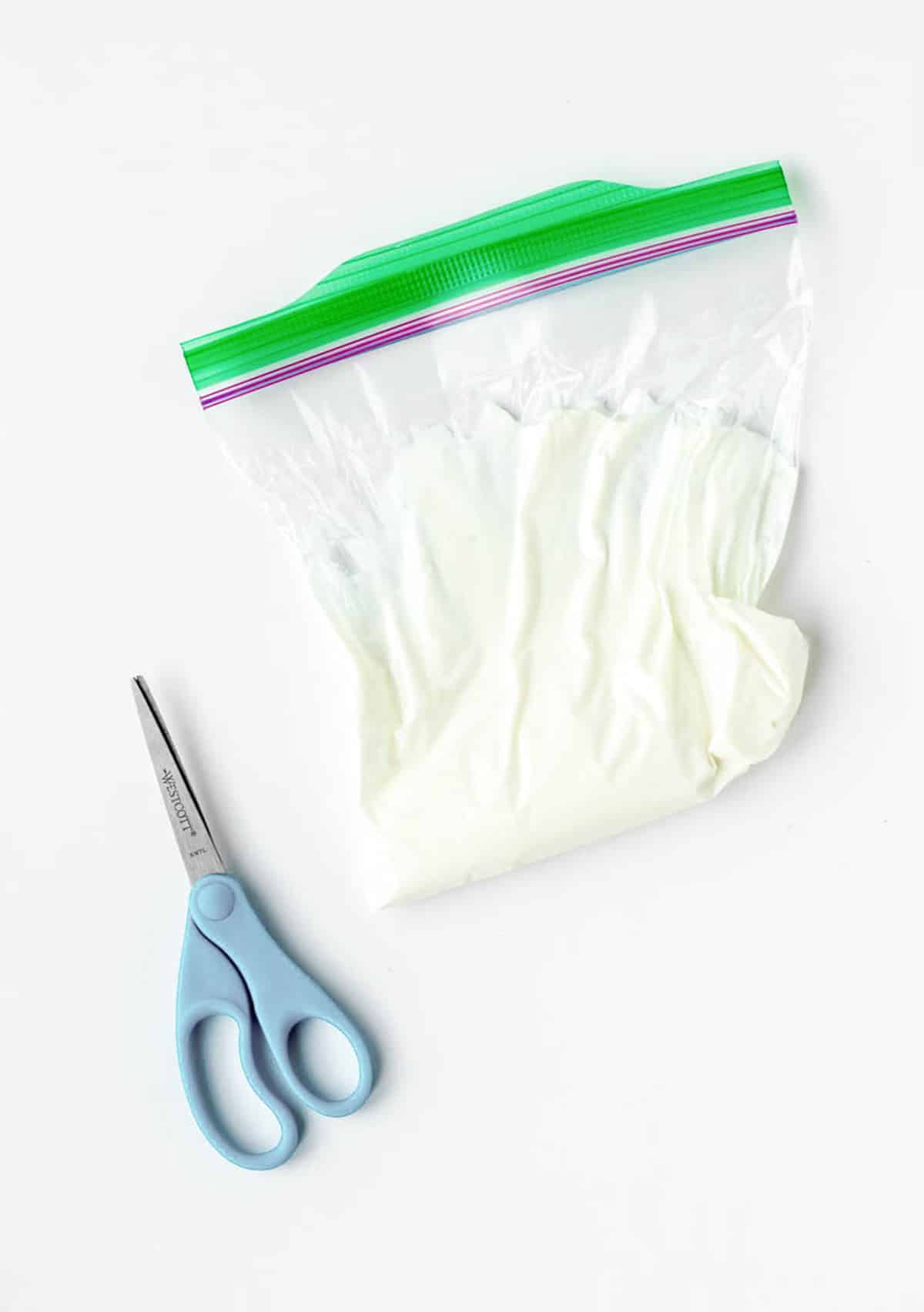 Scissors and a bag with Greek yogurt.