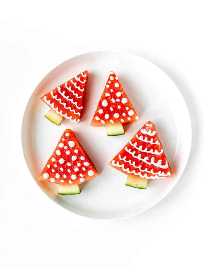 A white plate with four Christmas watermelon trees.