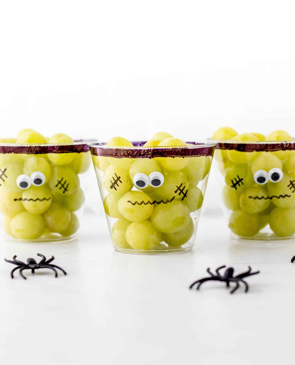 Three Frankenstein grape cups with spiders.
