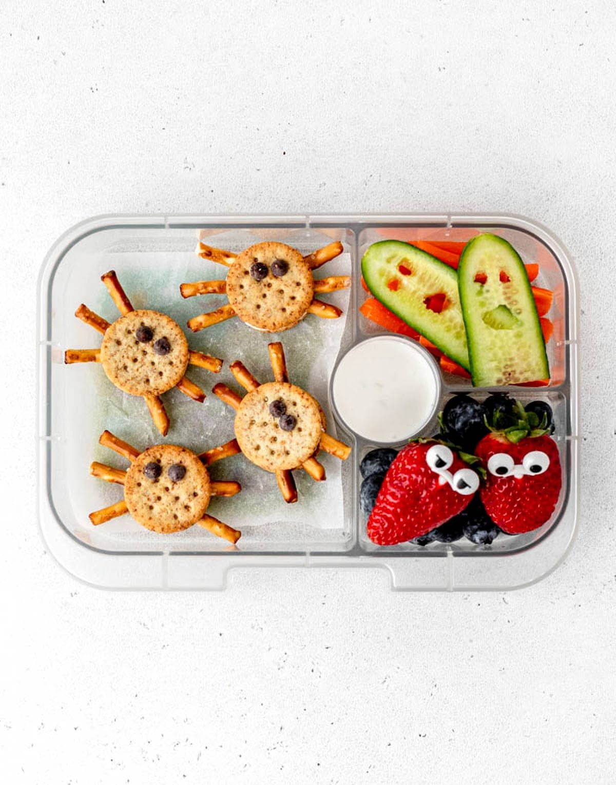 Halloween lunch box with spider crackers, ghost cucumbers and little fruit monsters.