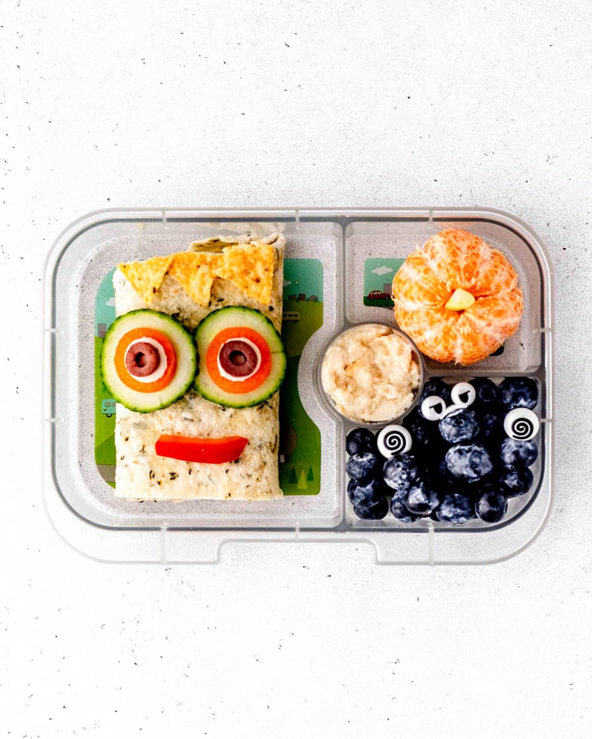 Halloween lunch box with monster wrap, tangerine pumpkin and blueberries monster picks.