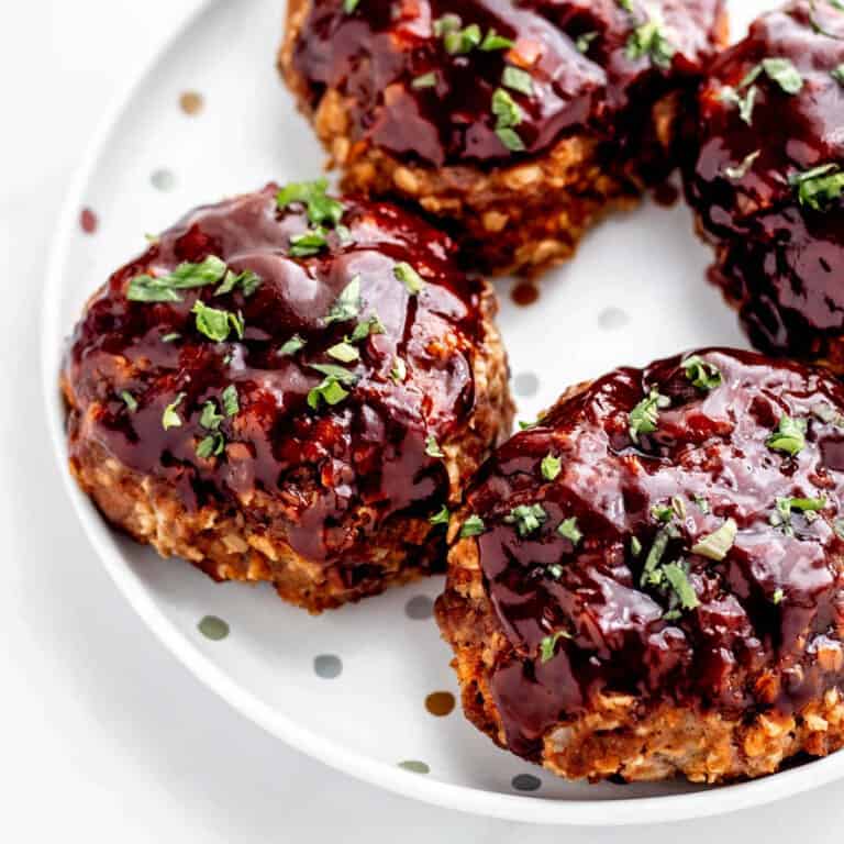 Up close image of four mini meatloaves on a polka dot plate.