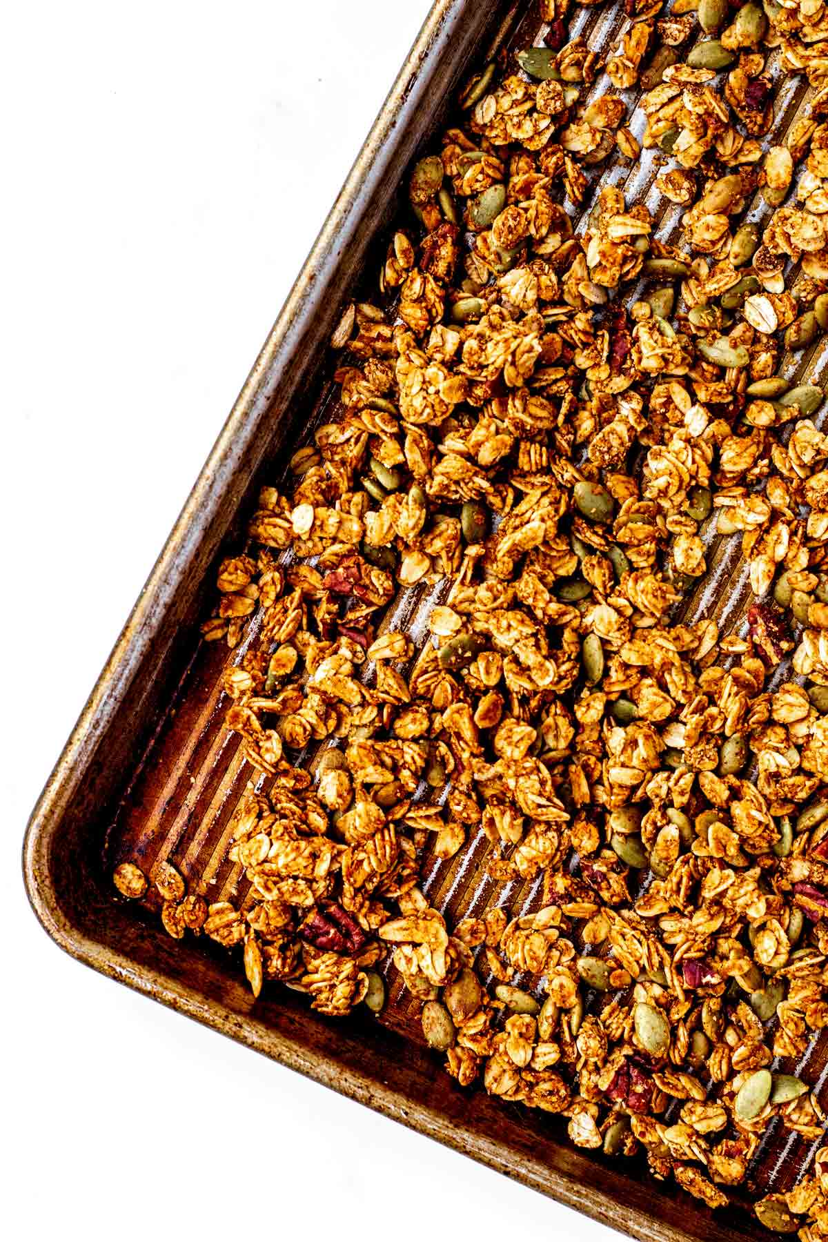 Close up of pumpkin and flax granola on a baking sheet.