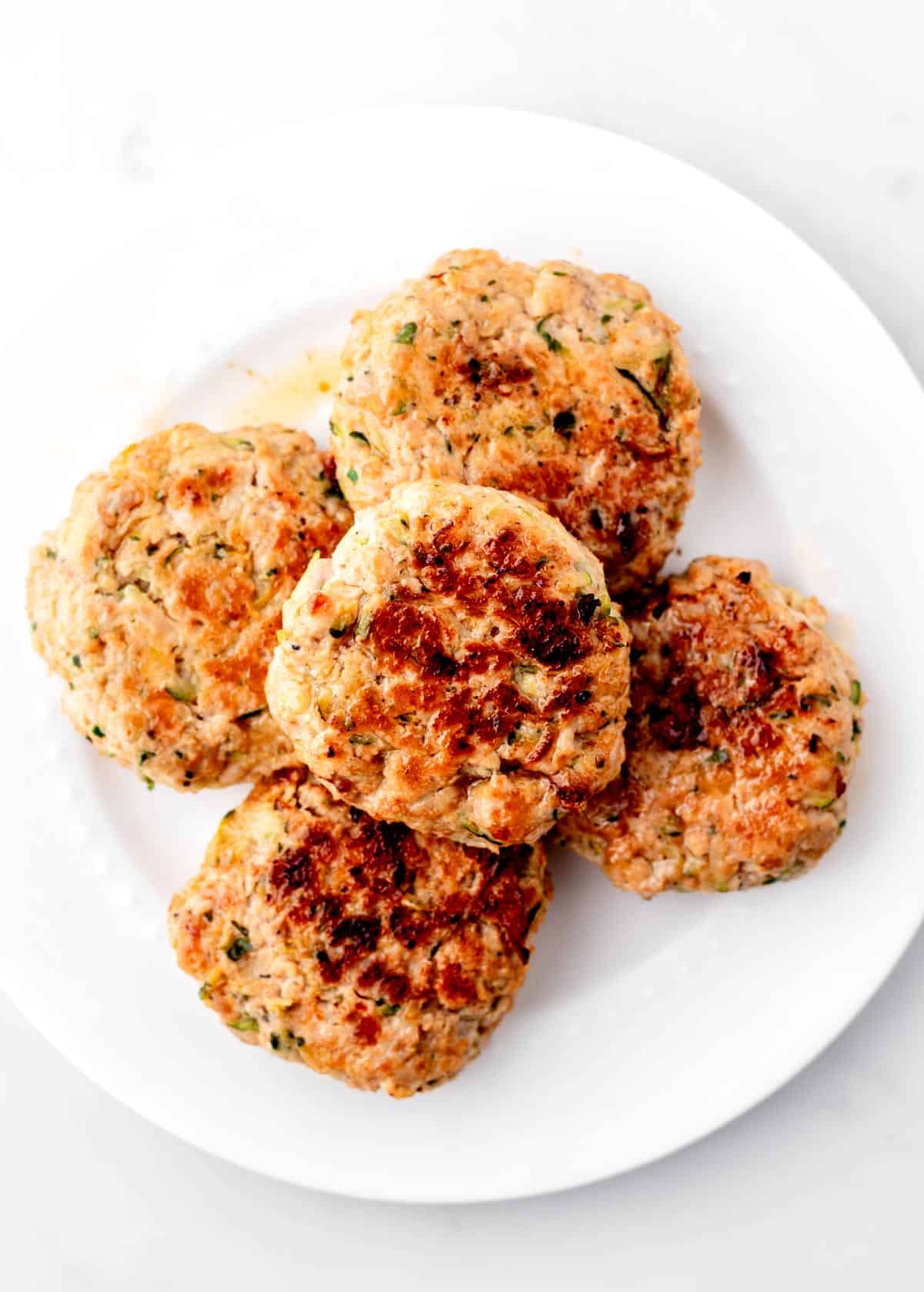 Cooked turkey burger sliders on a plate.