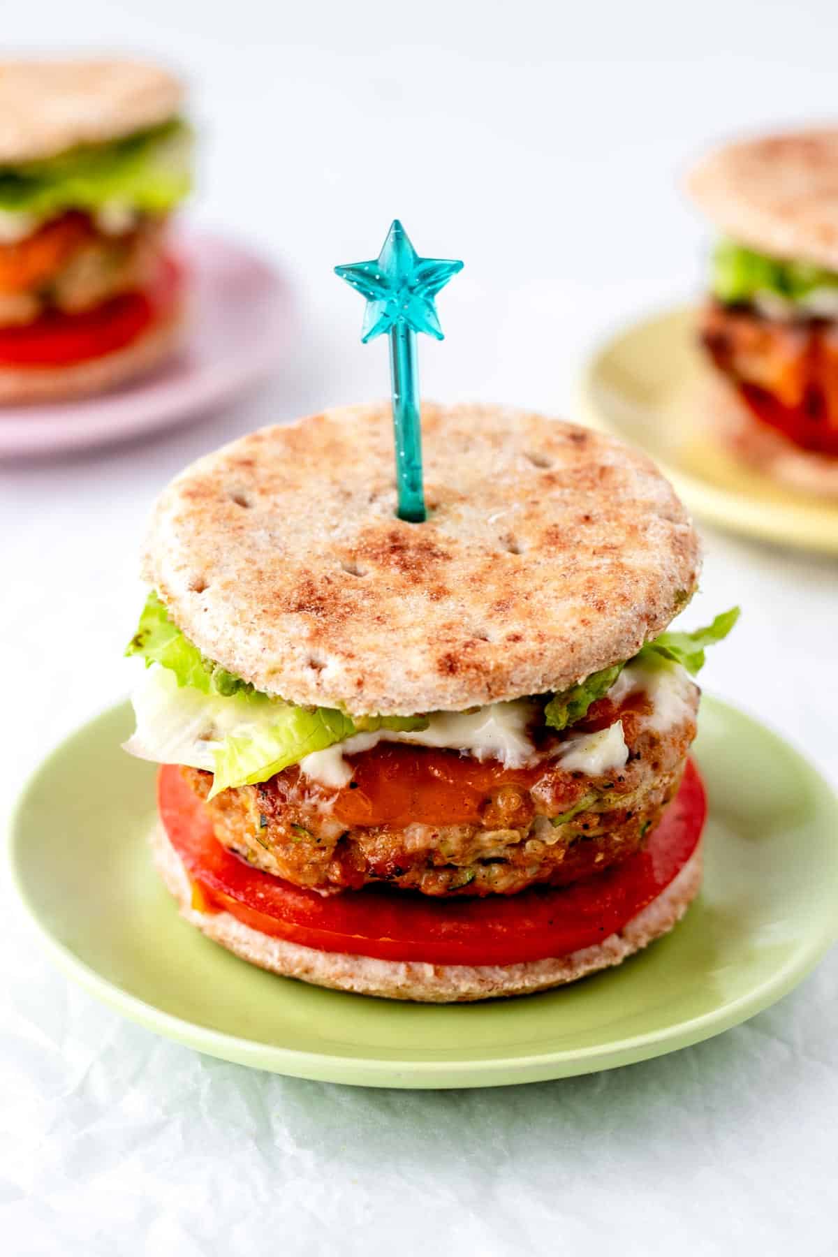 A turkey burger slider on a plate with a blue star pick.