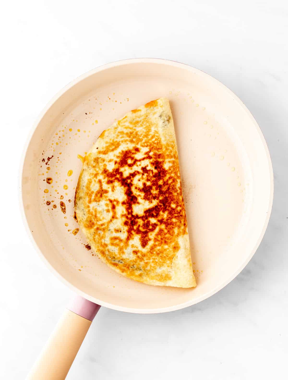 A baby led weaning quesadilla in a skillet.