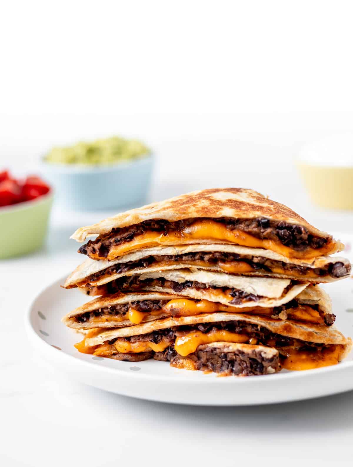 A stack of black bean and cheese quesadillas on a plate.