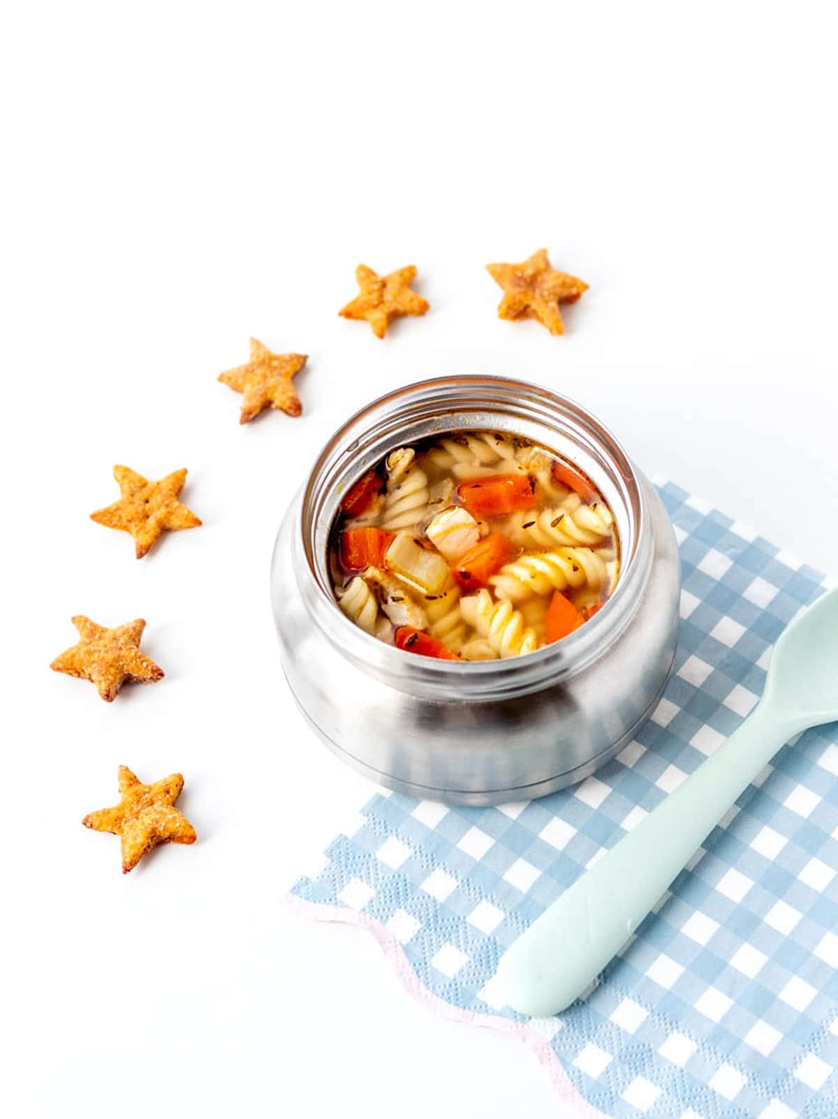 A thermos with chicken noodle soup and star crackers.