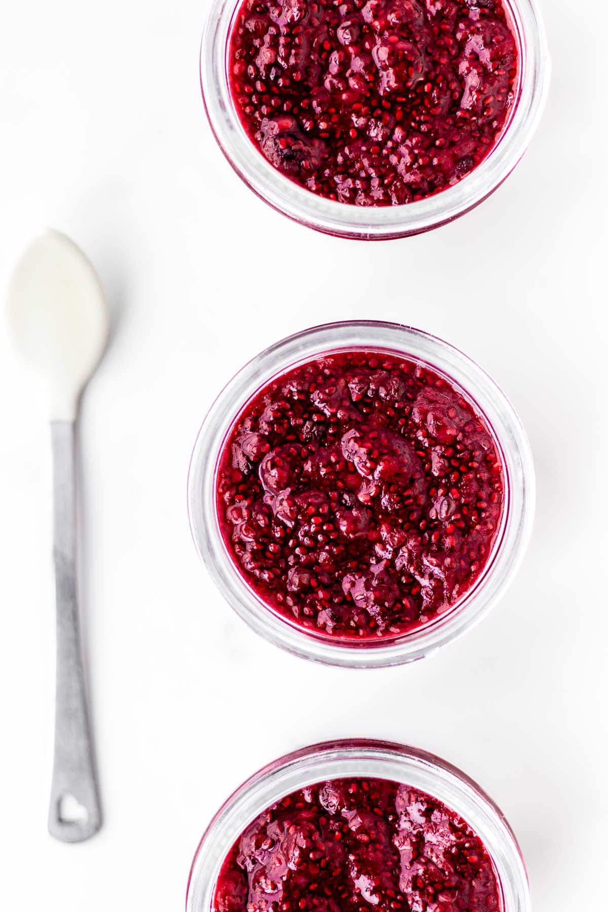 Close up image of berry jam for babies in three jars.