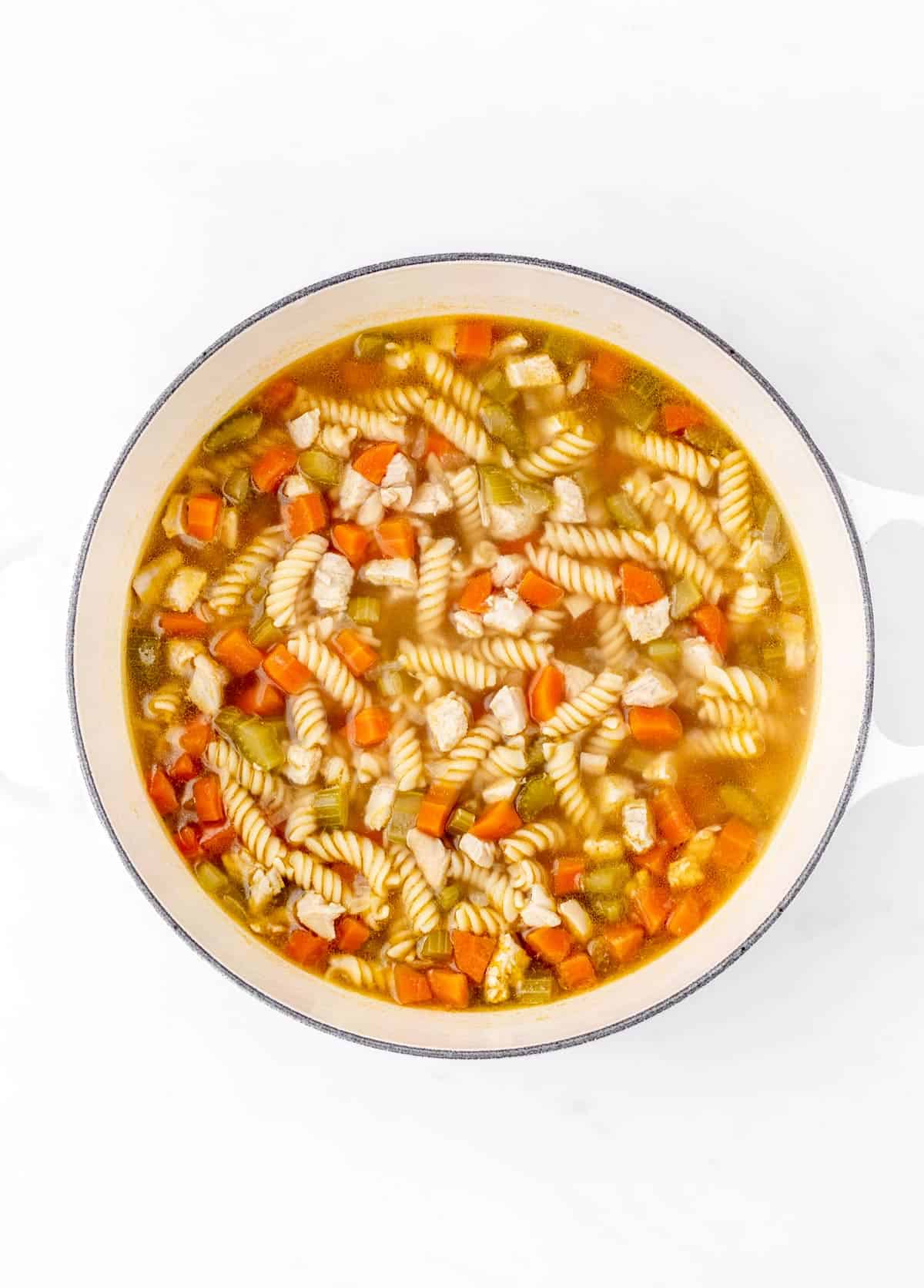 Chicken noodle soup for babies in a white bowl.