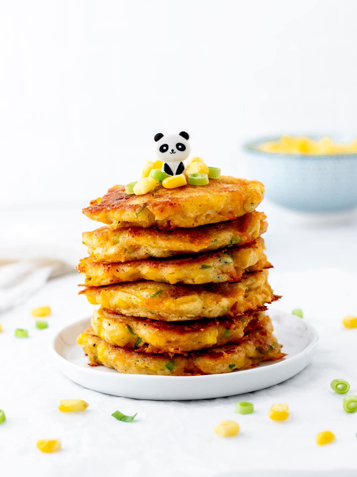 Healthy corn fritters stacked with little panda pick on top.