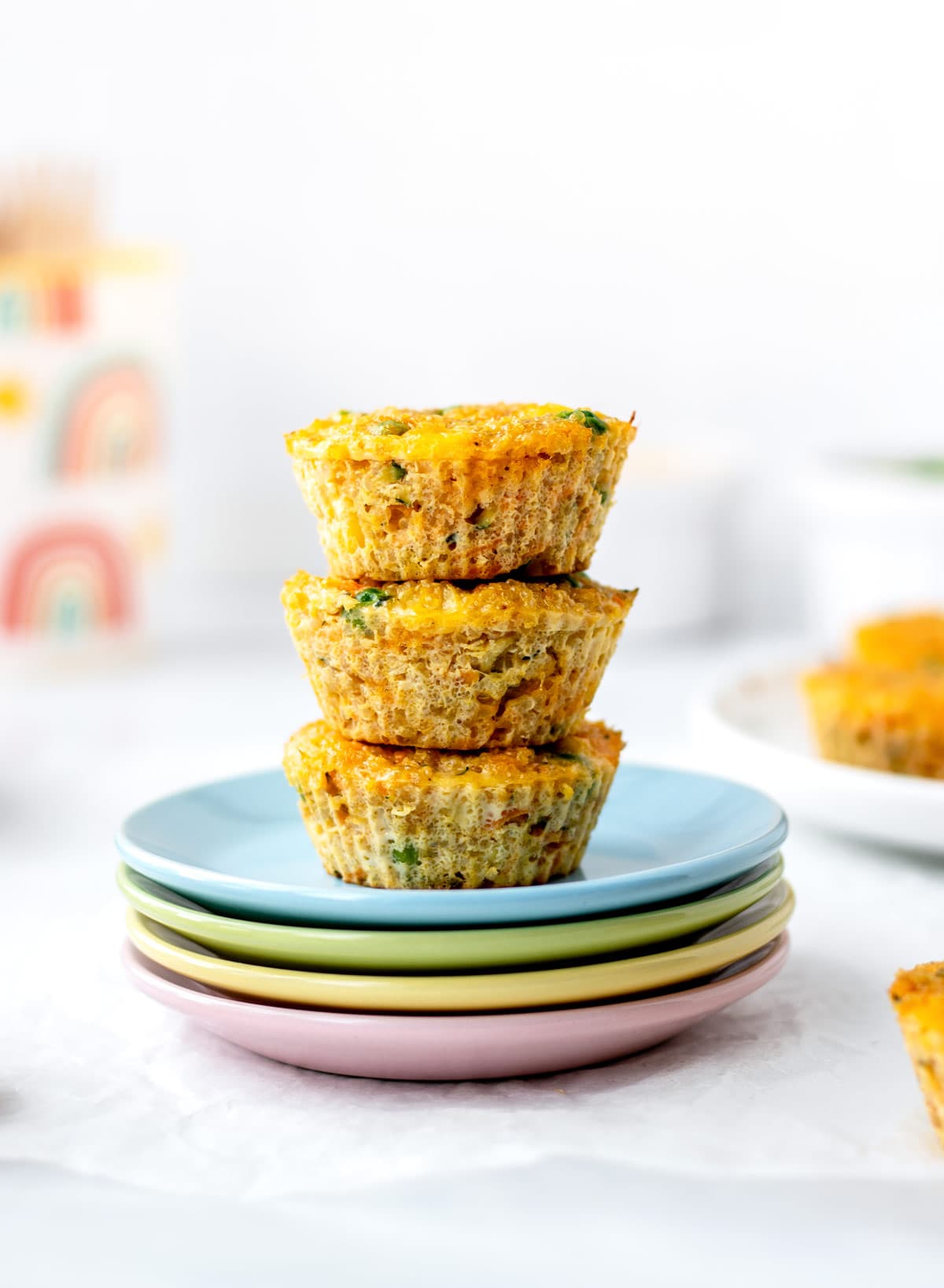 A stack of three quinoa veggie bites on colorful plates.