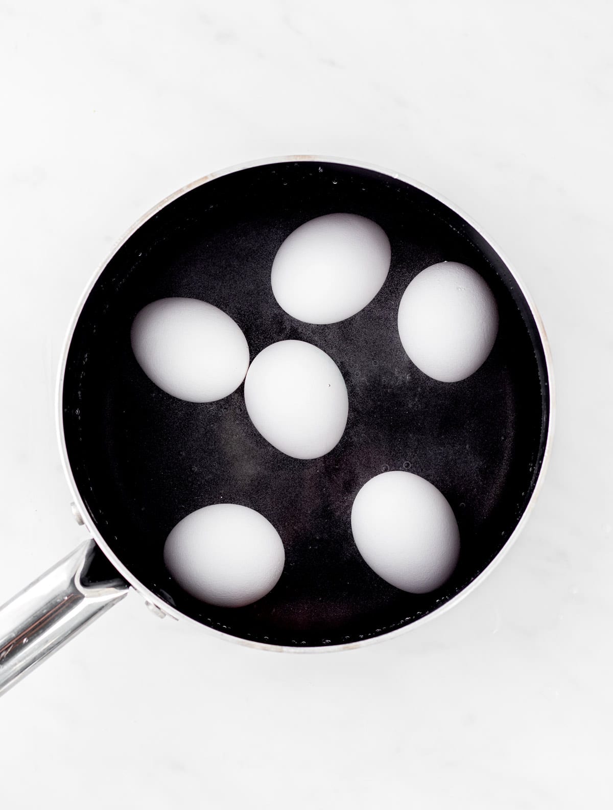 Hard boiled eggs in a black pot.