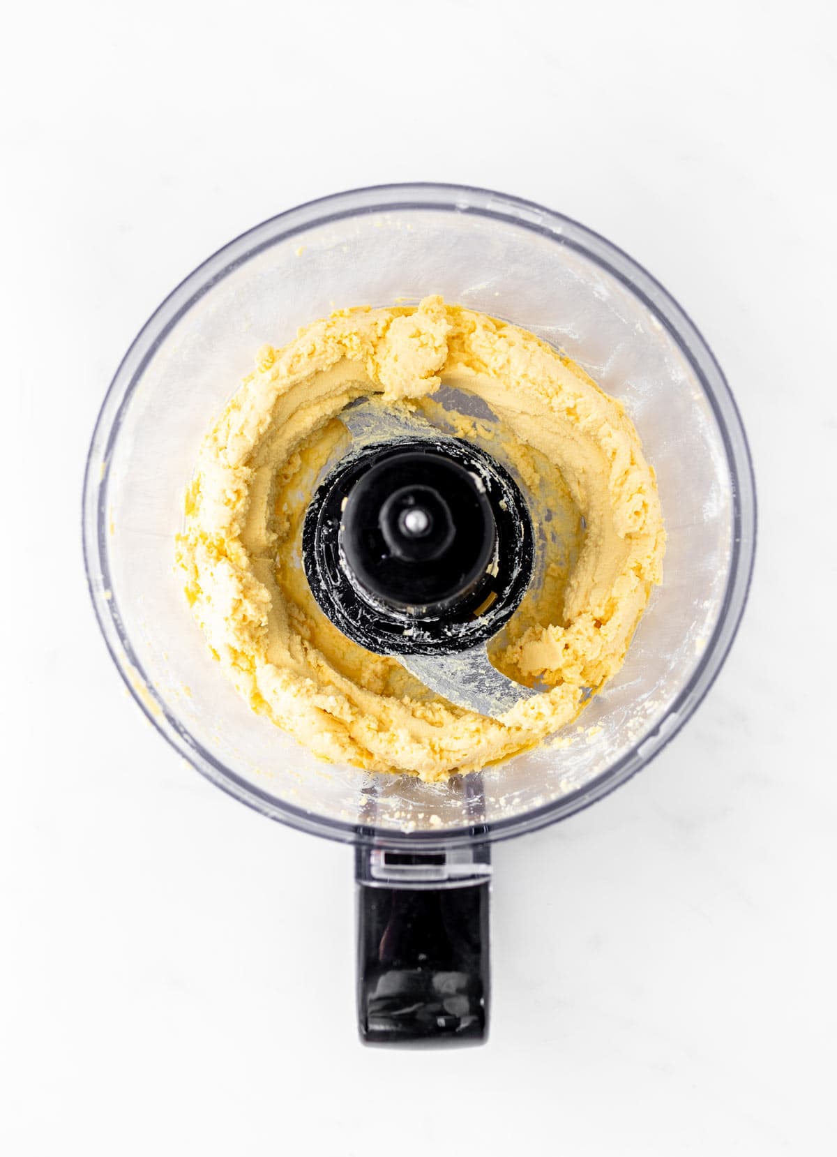 Fluffy Greek yogurt deviled egg mixture in a food processor.