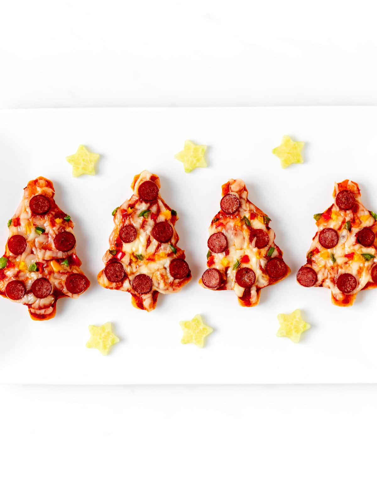 Four mini Christmas tree pizza with cucumber stars.