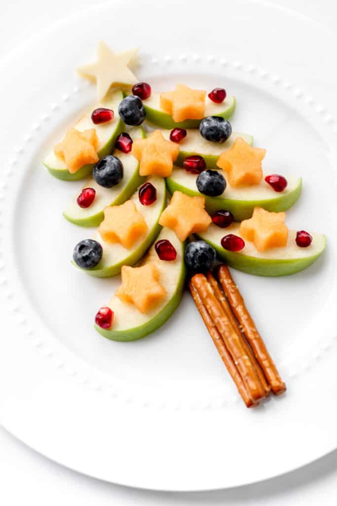 A fully assembled apple Christmas tree on a white, circular plate.