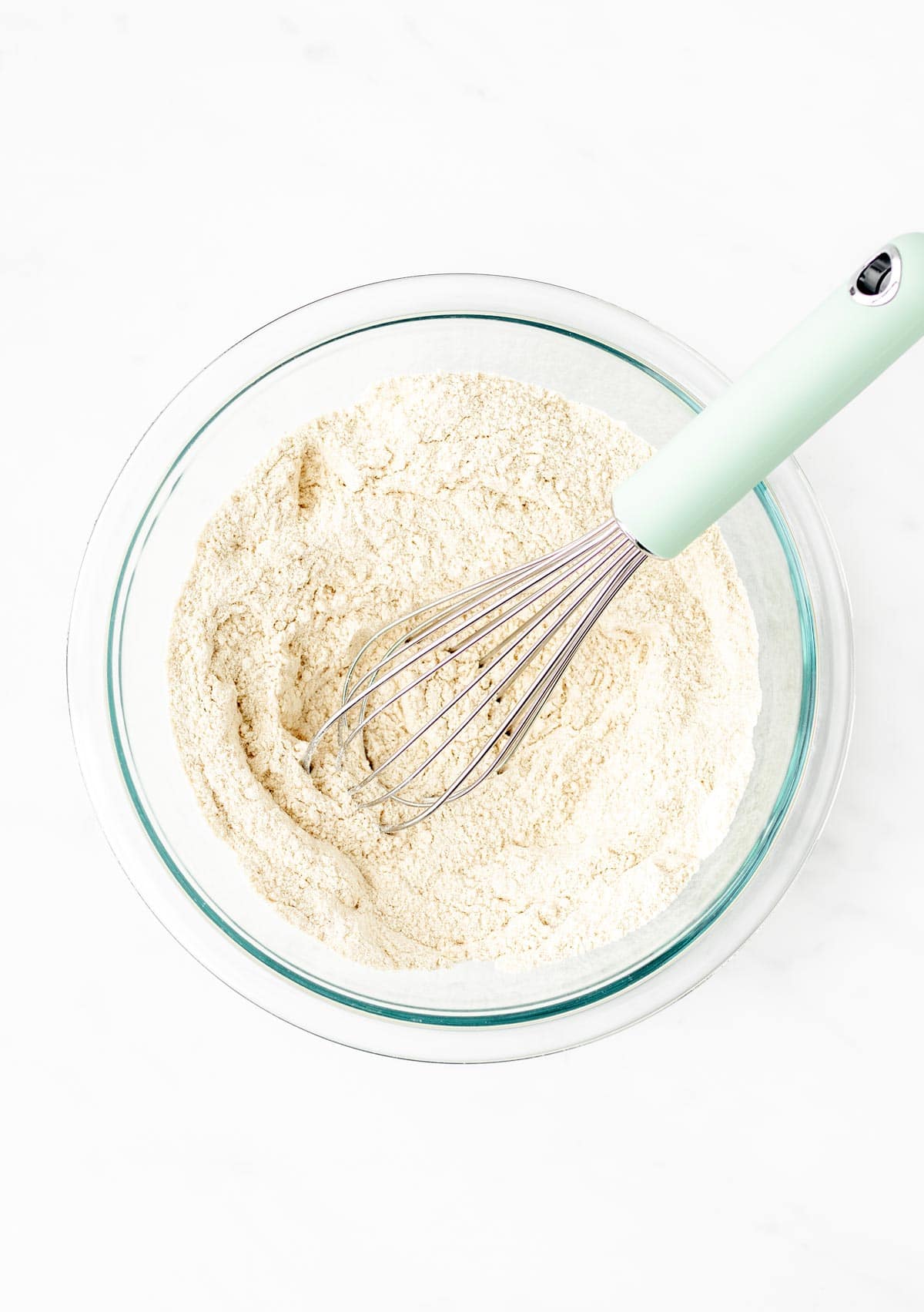 A whisk mixing together the dry ingredients for the Santa pancakes.