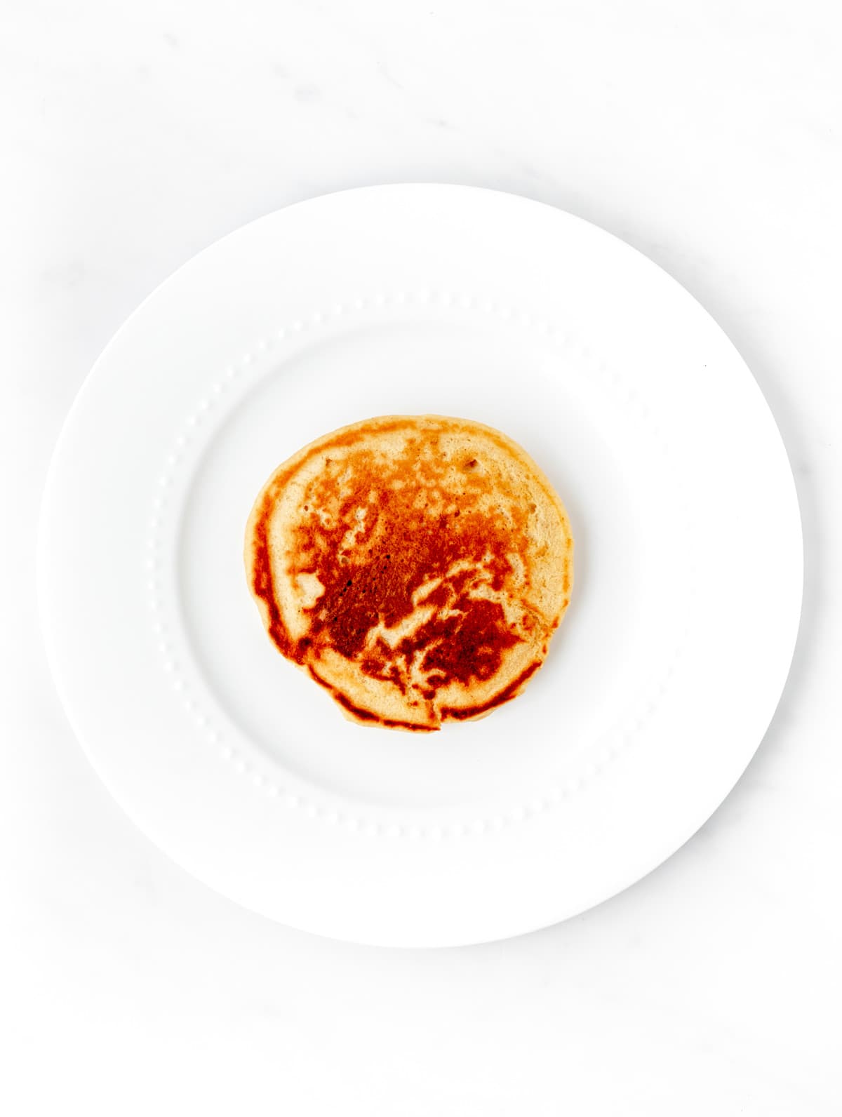 A cooked pancake on a white plate.