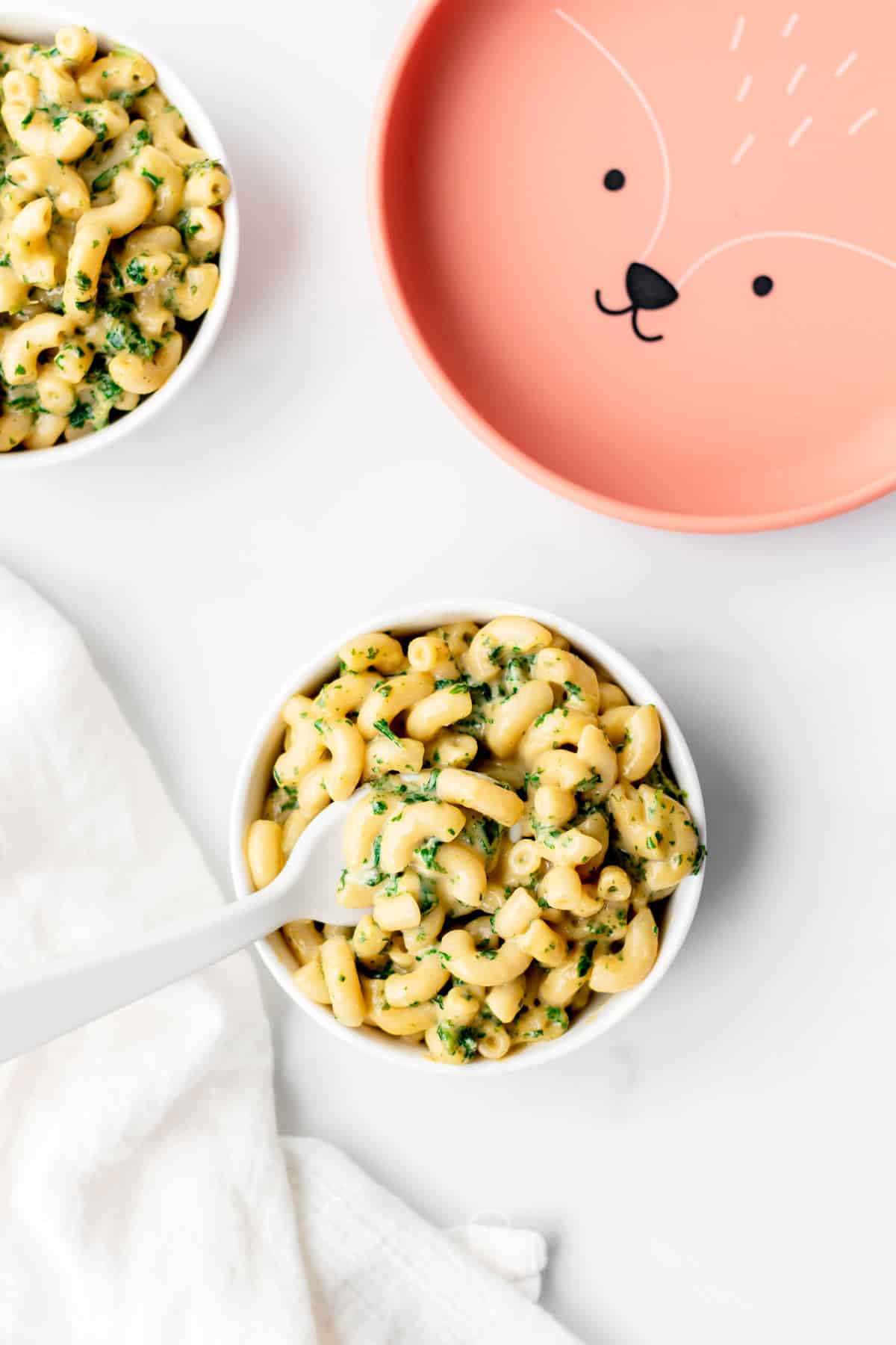 A bowl of kale mac and cheese on a table.