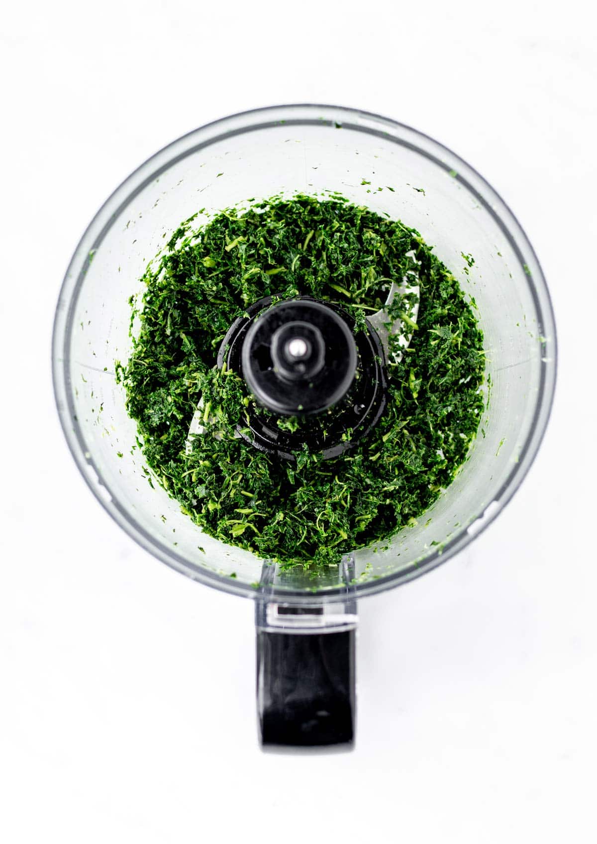 Kale being pulsed in a food processor for the kale mac and cheese.