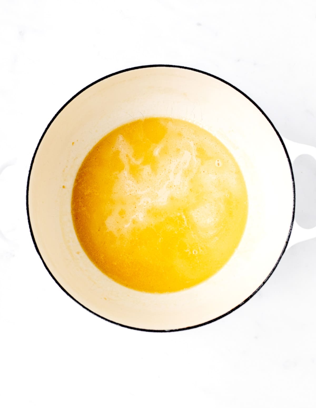 Melting butter and evaporated milk in a large pot.