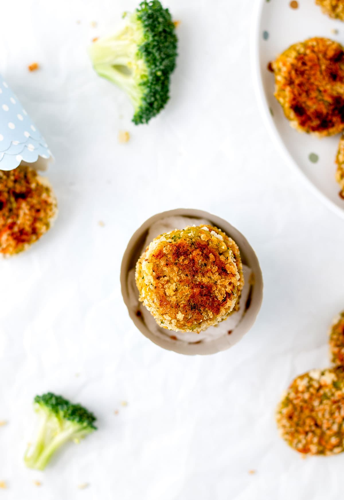 A birds-eye view of crispy chickpea nuggets stacked in a polka dotted cup.