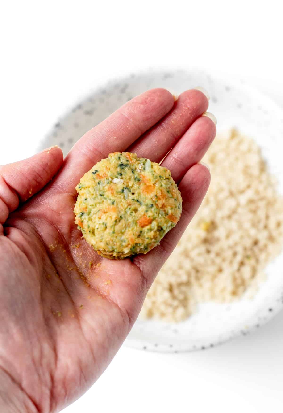 A flattened, round patty of the chickpea veggie mixture in someone's hand.