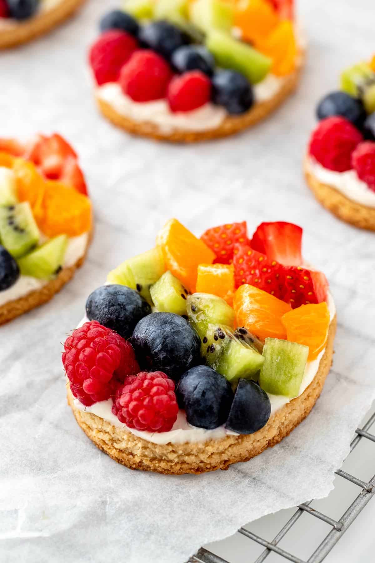 Close up image of Easter egg fruit pizza cookie on a cooling wrack.