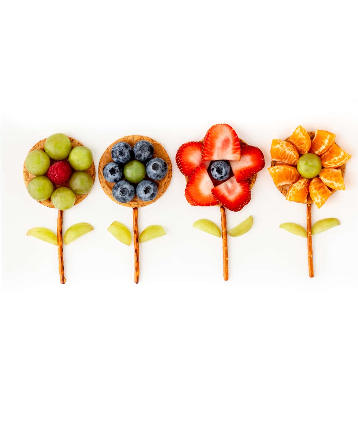 4 different flower crackers lined up on a white platter.