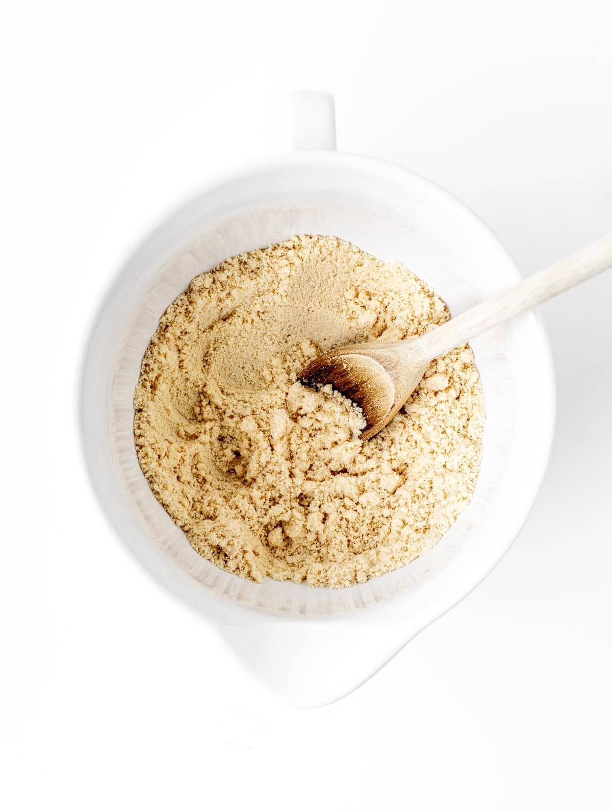 Combining the almond flour and salt in a large mixing bowl with a wooden spoon.