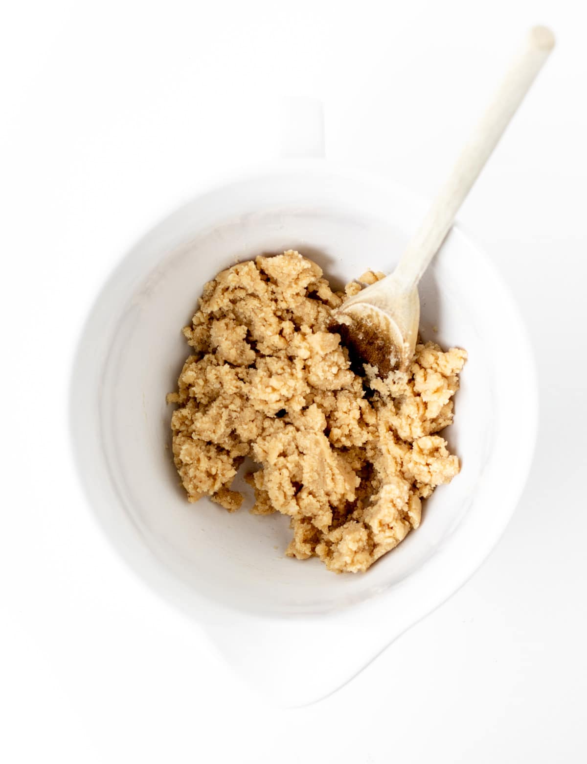 Combining the wet and dry ingredients with a wooden spoon in a large bowl.