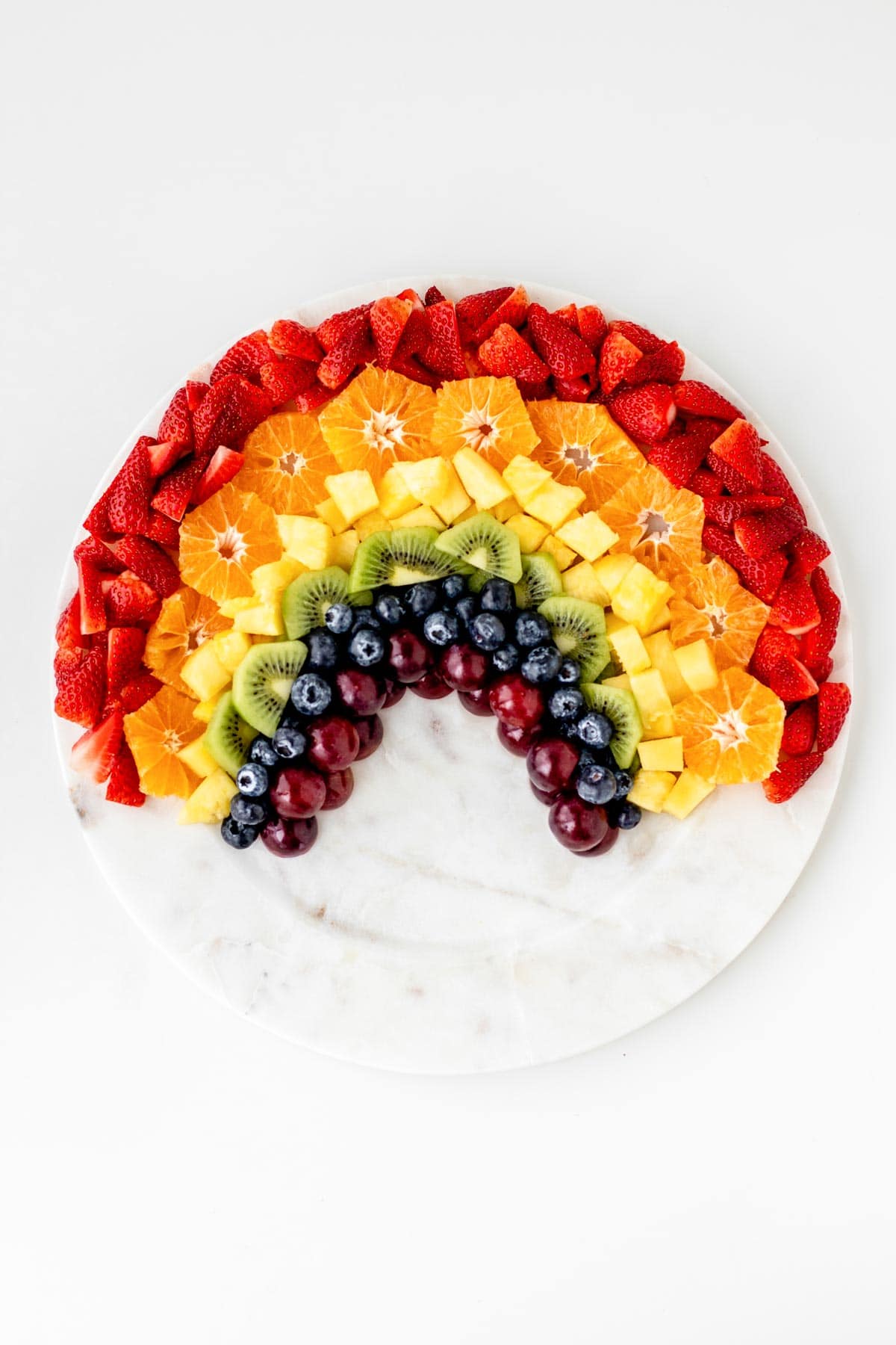 All of the fruit for the rainbow fruit tray arranged to look like a color rainbow.